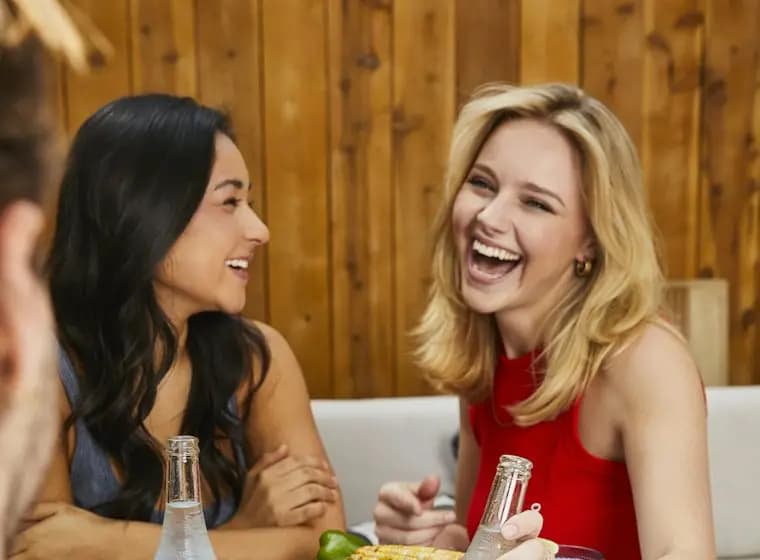 Two friends laughing over lunch